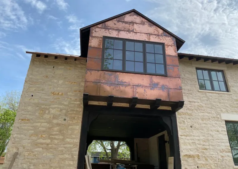Copper metal panel facade on a stone building for Roof Repair in Sandy Oaks